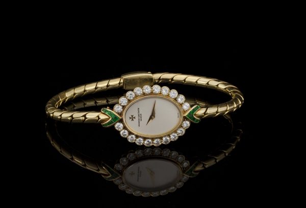 Vintage Vacheron Constantin 18ct Yellow Gold Watch with Diamonds and Emeralds; solid 18ct gold ladies manual wristwatch with diamond bezel accented with emerald set terminals. Made in Switzerland, Circa 1950s