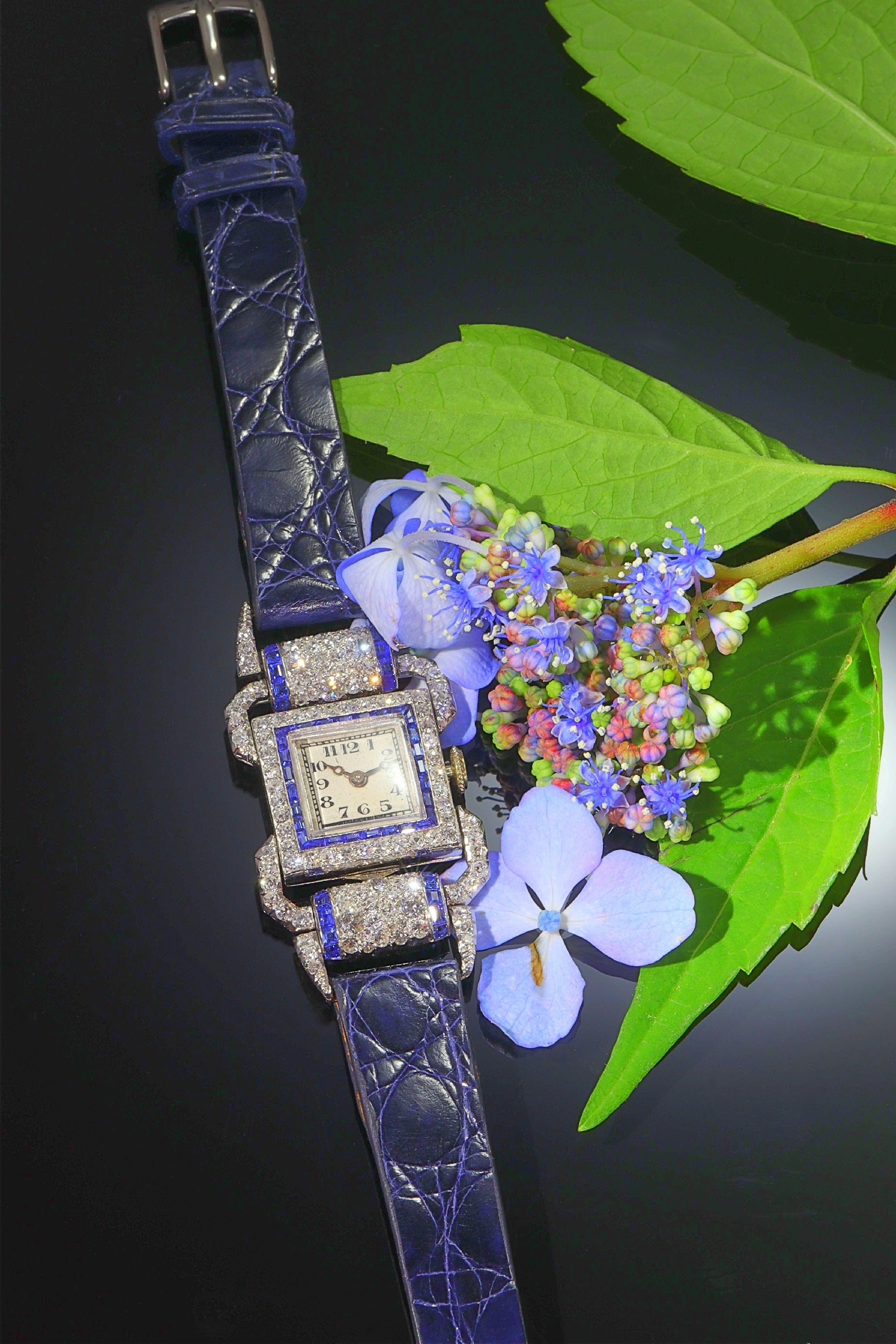 A ladies Art Deco design cocktail wristwatch set with diamonds and sapphires, on a blue leather strap, with flowers