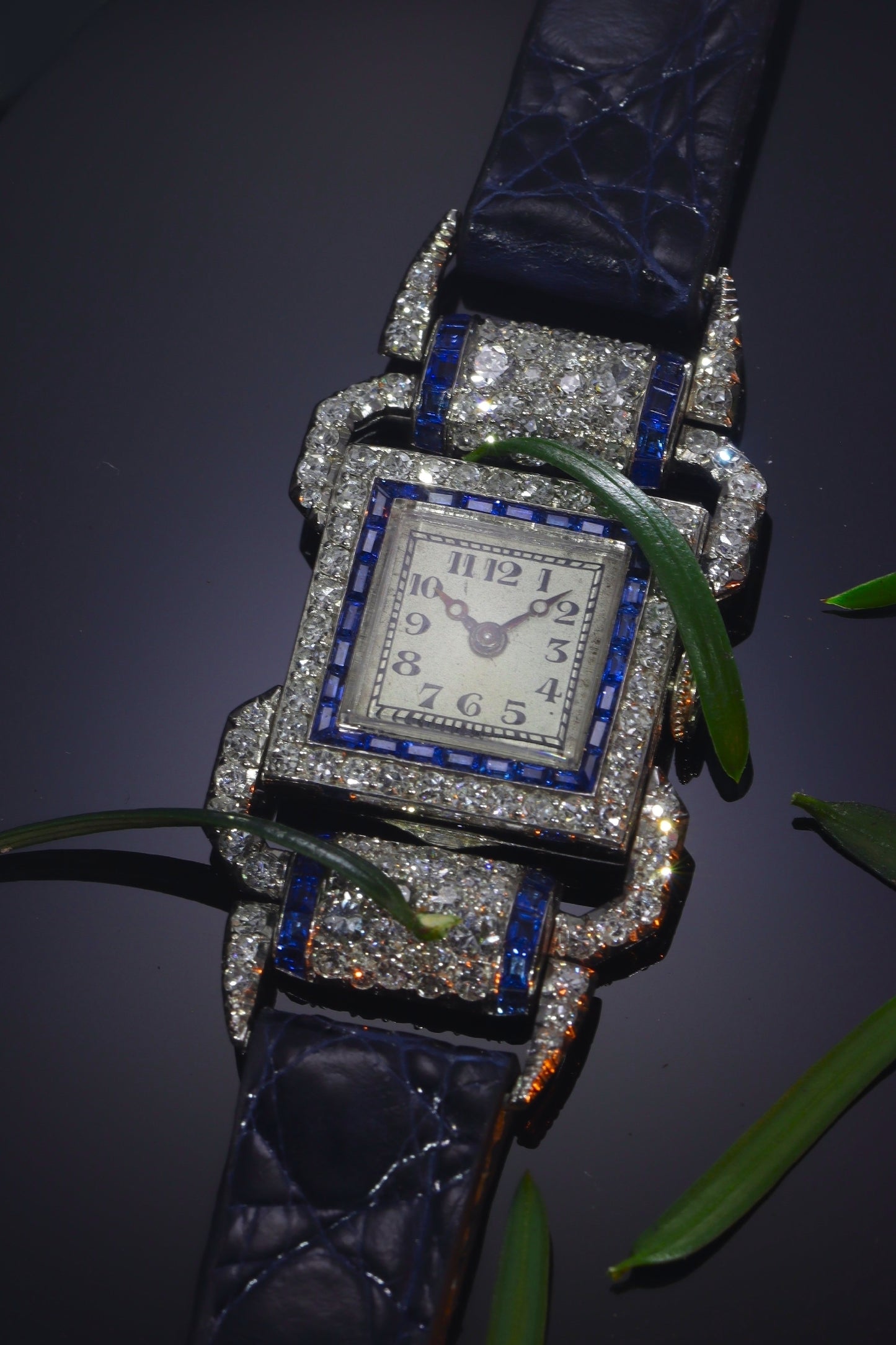 A ladies Art Deco design cocktail wristwatch set with diamonds and sapphires, on a blue leather strap