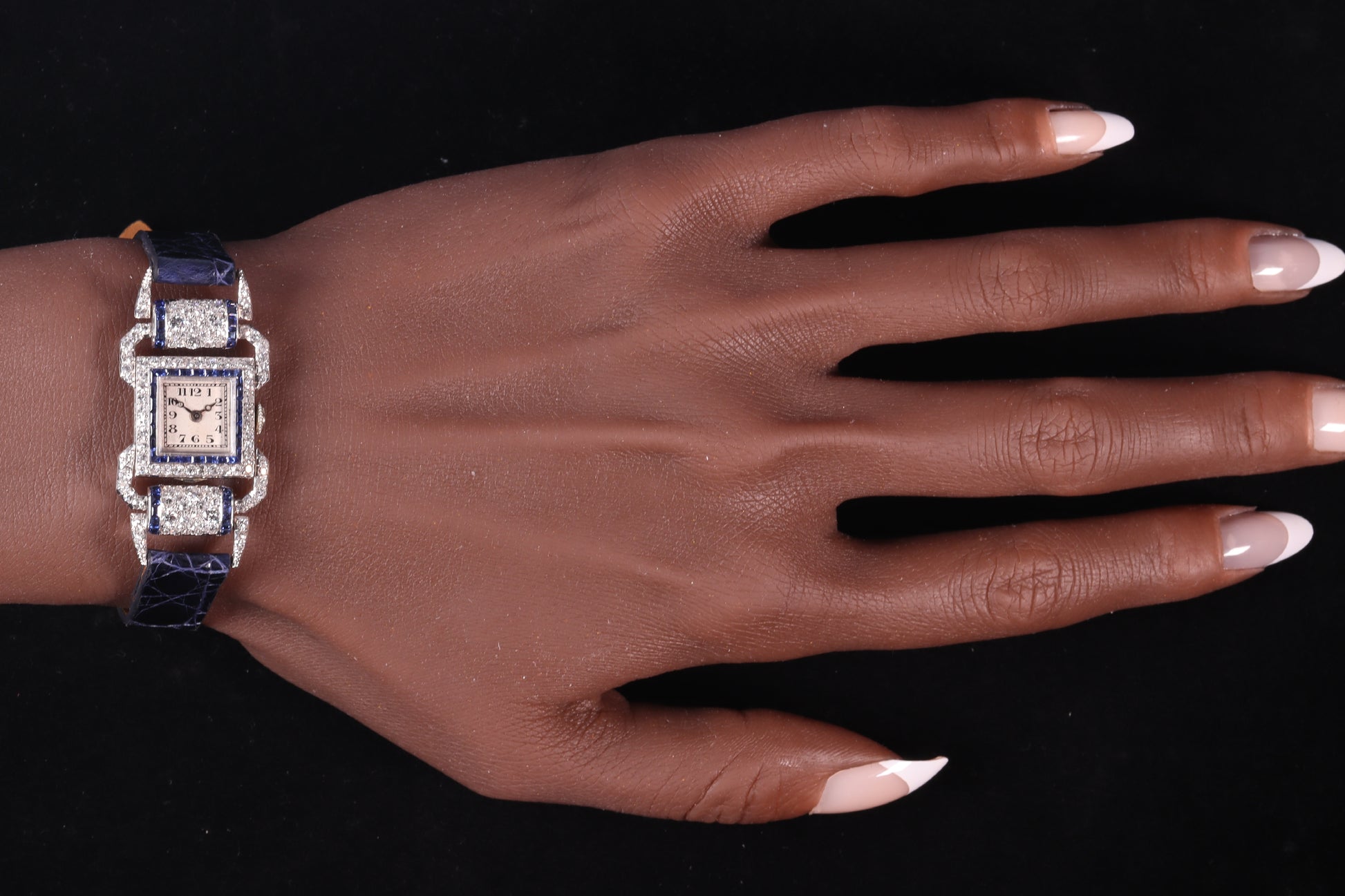 A ladies Art Deco design cocktail wristwatch set with diamonds and sapphires, on a blue leather strap, modelled on a wrist