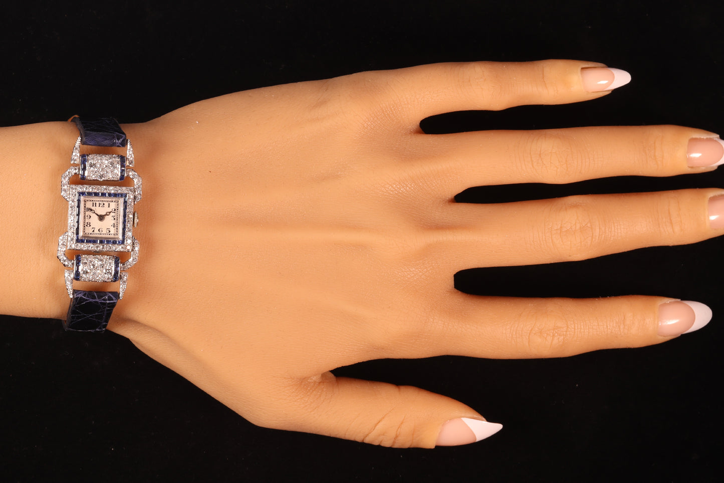 A ladies Art Deco design cocktail wristwatch set with diamonds and sapphires, on a blue leather strap, modelled on a wrist