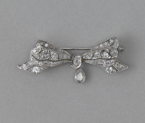 Antique Edwardian Old Cut Diamond and Platinum Bow Brooch, with 0.30ct pear shaped diamond drop, 1.30 carat total. Netherlands, circa 1915