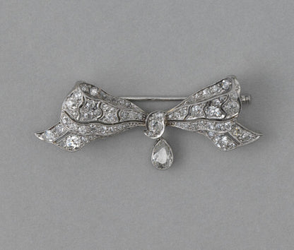 Antique Edwardian Old Cut Diamond and Platinum Bow Brooch, with 0.30ct pear shaped diamond drop, 1.30 carat total. Netherlands, circa 1915