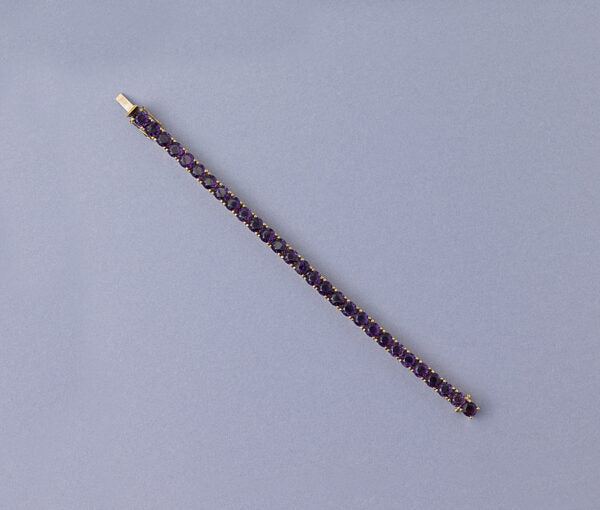 Modern Amethyst Line Bracelet; set with 29 round faceted deep purple amethysts. Mounted in 14ct yellow gold.