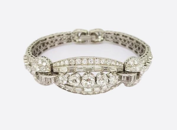 Vintage Diamond and Platinum Panel Bracelet; five graduated round-cut diamonds surrounded by baguette and circular-cut diamonds, 16.50 carat total
