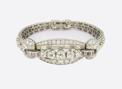Vintage Diamond and Platinum Panel Bracelet; five graduated round-cut diamonds surrounded by baguette and circular-cut diamonds, 16.50 carat total