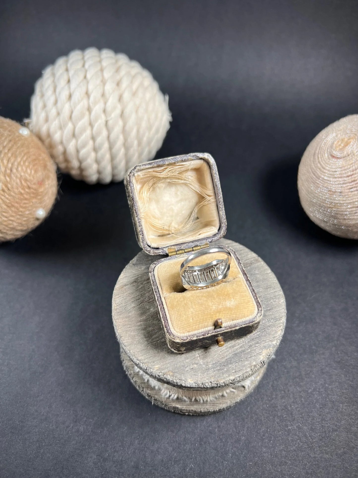 A three row diamond band ring in platinum in an antique ring box