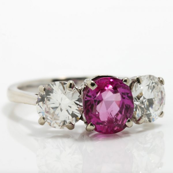 Natural Pink Sapphire and Diamond Three Stone Ring; central 1.50ct natural pink sapphire flanked by 2cts round brilliant-cut diamonds, all claw set in platinum