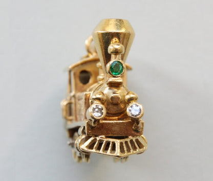 Vintage Van Cleef and Arpels 18ct Gold Locomotive Train Charm; with diamond and emerald set headlights, Signed and numbered 97265, with Van Cleef & Arpels 18ct gold chain bracelet.