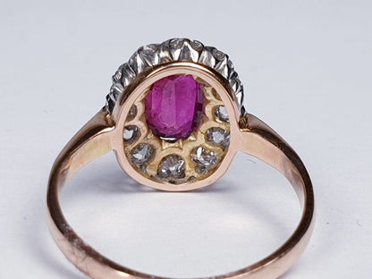 Antique Victorian Ruby and Diamond Oval Cluster Ring; featuring a 1.15 carat oval faceted ruby encompassed by 1.20cts sparkling diamonds, on a rose gold shank. English, Circa 1890