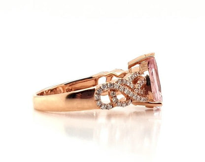 Pear Cut Morganite and Diamond Cluster Dress Ring; central 1.75 carat pear-shaped morganite flanked by 0.33cts diamond set overlapping waves and swirls, in 18ct rose gold