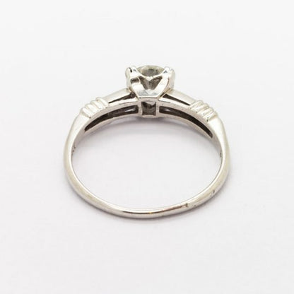 Vintage 0.61ct Diamond Engagement Ring in Platinum; single stone diamond ring featuring a 0.61 carat round brilliant-cut diamond, four claw set, with diamond set shoulders. Circa 1940. Accompanied by a diamond certificate