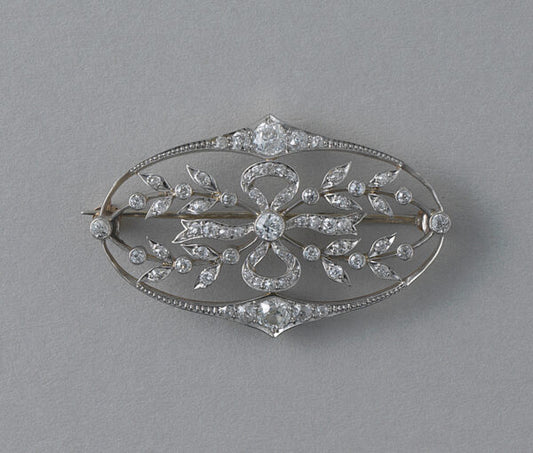 Antique Edwardian Diamond Oval Floral Bow Brooch; set with 67 old cut diamonds, 1.50 carat total, openwork bow and delicate design. Set in platinum and backed with yellow gold. Dutch, Circa 1910