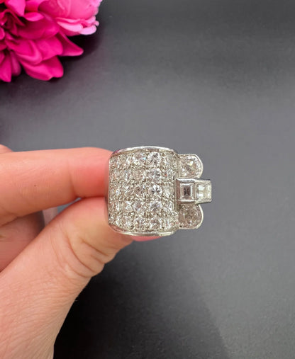 A round diamond tank style cocktail ring in platinum, held in a hand