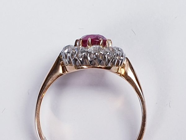 Antique Victorian Ruby and Diamond Oval Cluster Ring; featuring a 1.15 carat oval faceted ruby encompassed by 1.20cts sparkling diamonds, on a rose gold shank. English, Circa 1890