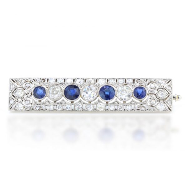 Art Deco Old Cut Diamond, Sapphire and Platinum Brooch, exquisite pierced platinum design encrusted with diamonds, encompassing the central row of alternating old cut diamonds and sapphires. Circa 1920s