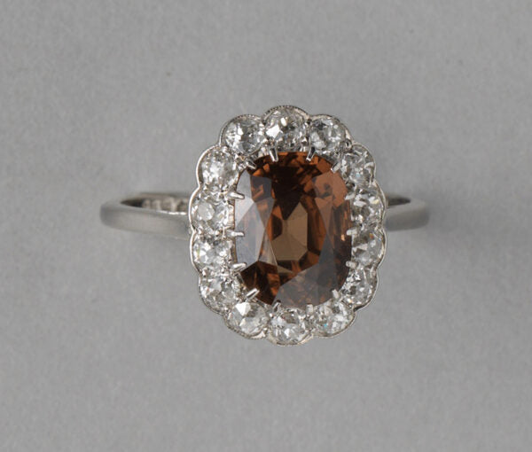 Antique Edwardian Zircon, Old Cut Diamond and Platinum Oval Cluster Ring; 2.27ct brown oval faceted zircon surrounded by 0.89cts old cut diamonds
