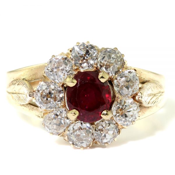 Antique Ruby and Old Cut Diamond Cluster Ring; central 0.75 carat natural ruby surrounded by 1.35 carats of old cut diamonds, in 18ct yellow gold with delicate leaf detailing to the shoulders. Made in England, Circa 1930