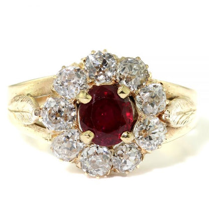 Antique Ruby and Old Cut Diamond Cluster Ring; central 0.75 carat natural ruby surrounded by 1.35 carats of old cut diamonds, in 18ct yellow gold with delicate leaf detailing to the shoulders. Made in England, Circa 1930