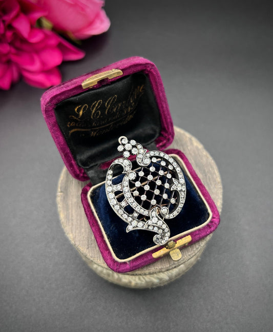 An openwork diamond set antique brooch in yellow gold and silver, in an antique box