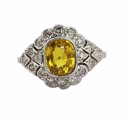 Yellow Sapphire and Diamond Cocktail Ring; 2.10 carat oval-cut yellow sapphire surrounded by 065cts diamonds, set into an intricate 18ct white gold mount.