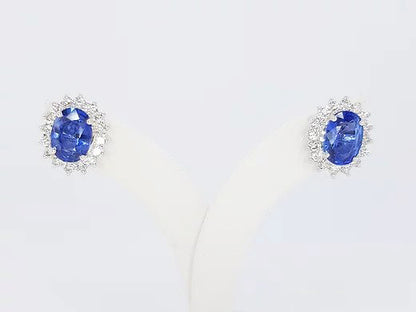 Sapphire and Diamond Oval Cluster Earrings; 2.46cts oval faceted sapphire surrounded by 0.78cts brilliant-cut diamonds, in 18ct white gold.