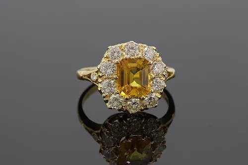 Yellow Sapphire and Diamond Cluster Ring; 2.90ct octagonal cut yellow sapphire surrounded by 1.35cts diamonds, mounted in 18ct yellow gold.