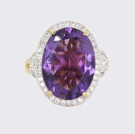 Amethyst and Diamond Oval Cluster Ring; oval amethyst, four-claw set, surrounded by dazzling diamonds, diamond set shoulders, mounted in 18ct yellow gold