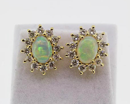 Opal and Diamond Oval Cluster Stud Earrings; featuring oval cabochon opals surrounded by diamonds, claw set, in 18ct yellow gold.