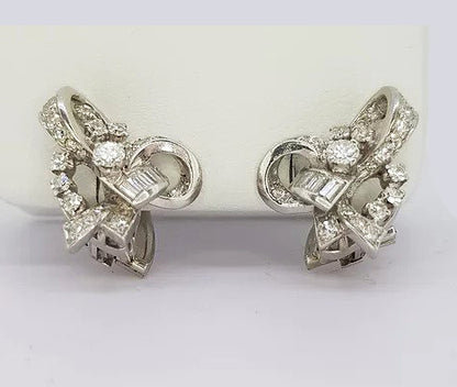 Vintage 1960's Diamond Set Bow Earrings; Intricate cluster earrings set with baguette and round brilliant-cut diamonds, in 18ct white gold. Clip on fittings