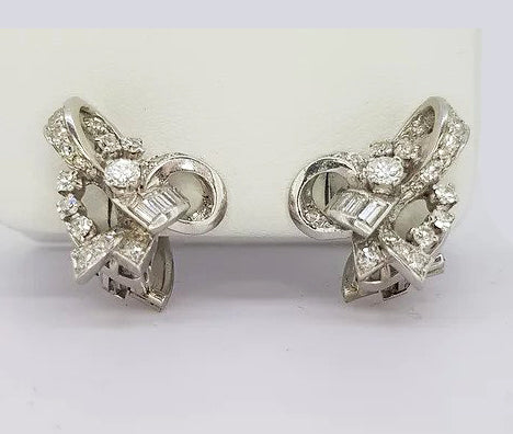 Vintage 1960's Diamond Set Bow Earrings; Intricate cluster earrings set with baguette and round brilliant-cut diamonds, in 18ct white gold. Clip on fittings