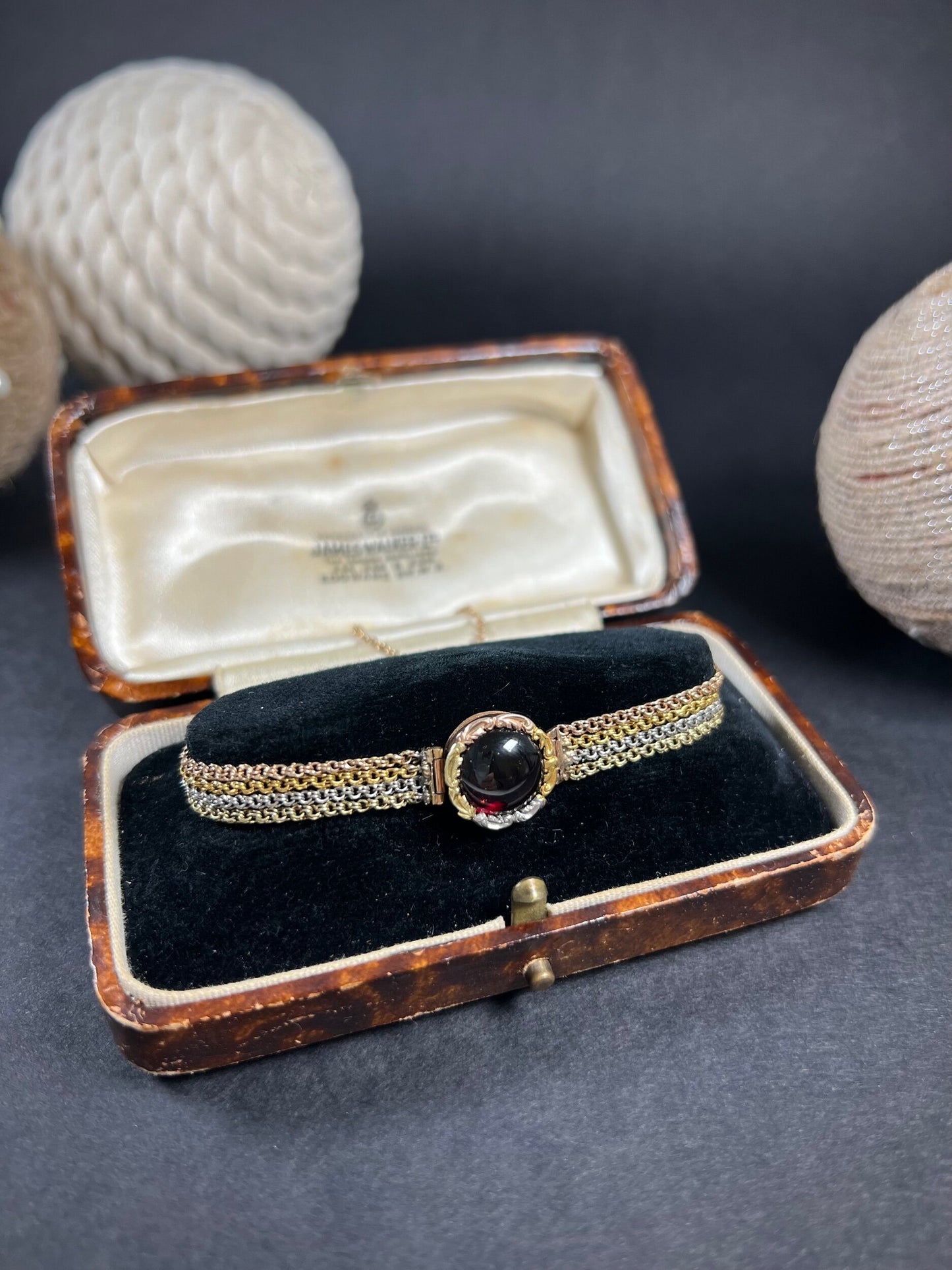 A cabochon garnet bracelet with three colour gold chains, in an antique box