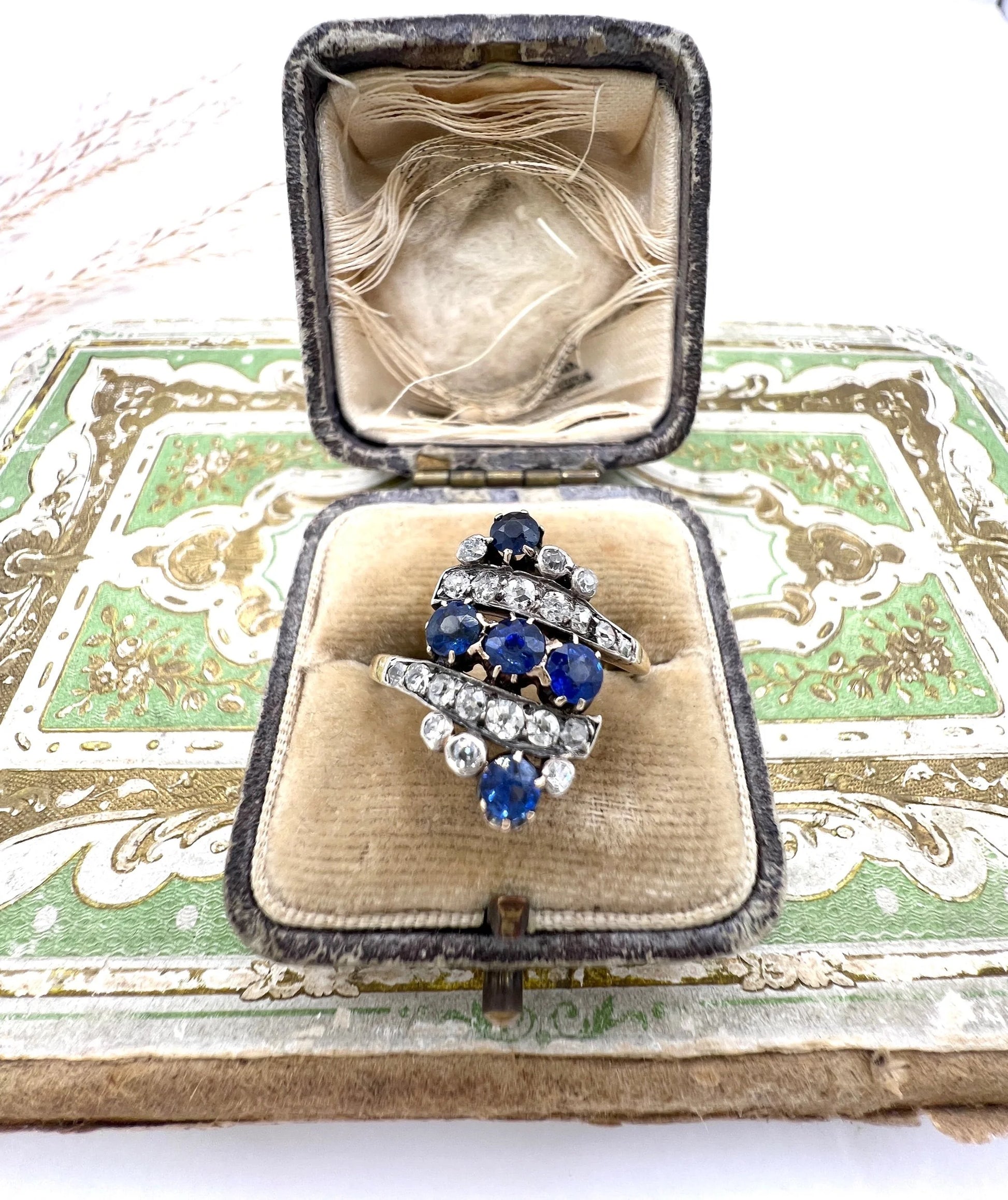 A navette shaped sapphire and diamond ring in yellow gold, in an antique ring box