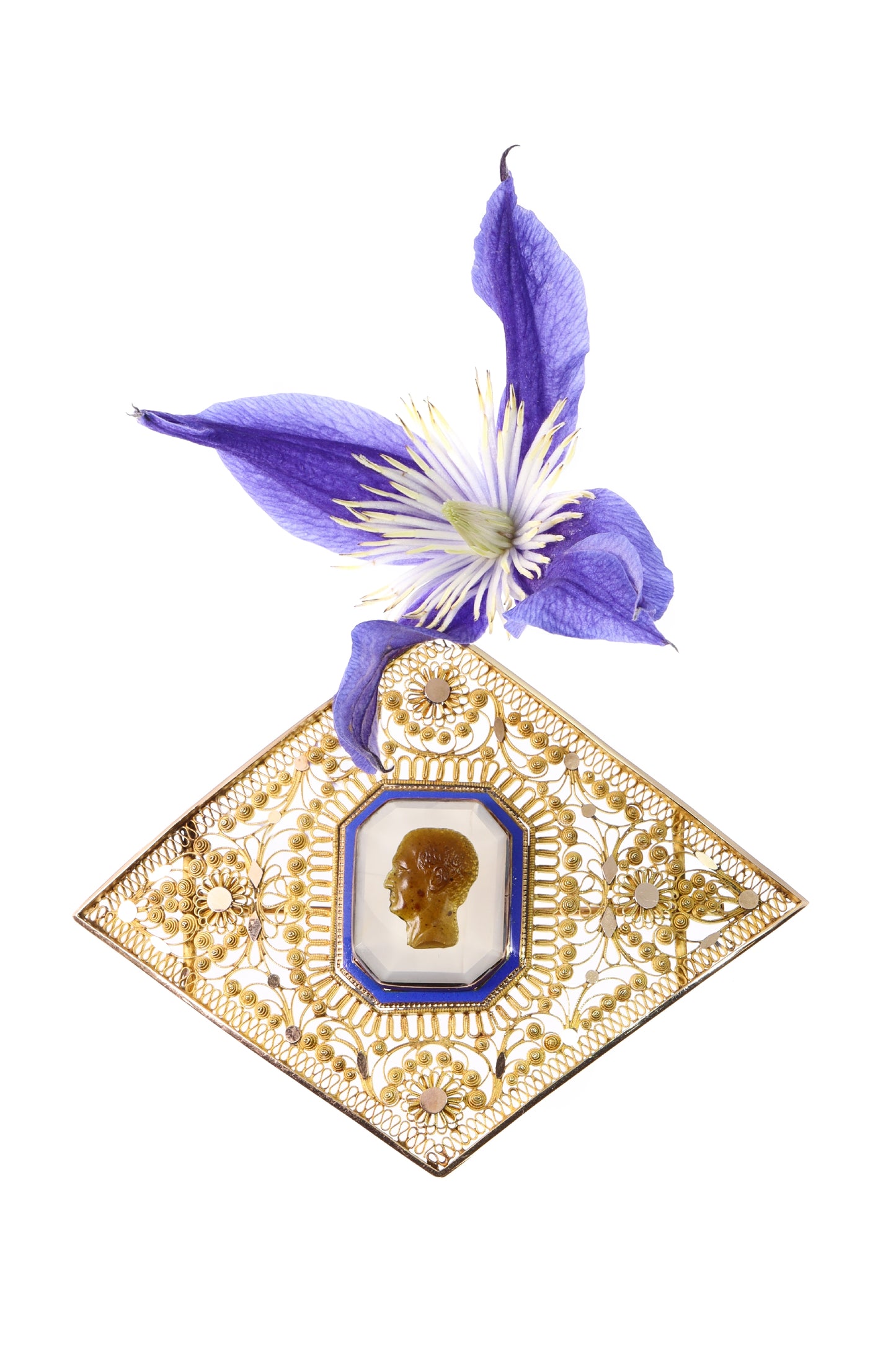 A yellow gold ornate openwork brooch with an agate cameo portrait in the centre, bordered with blue enamel, with a purple flower