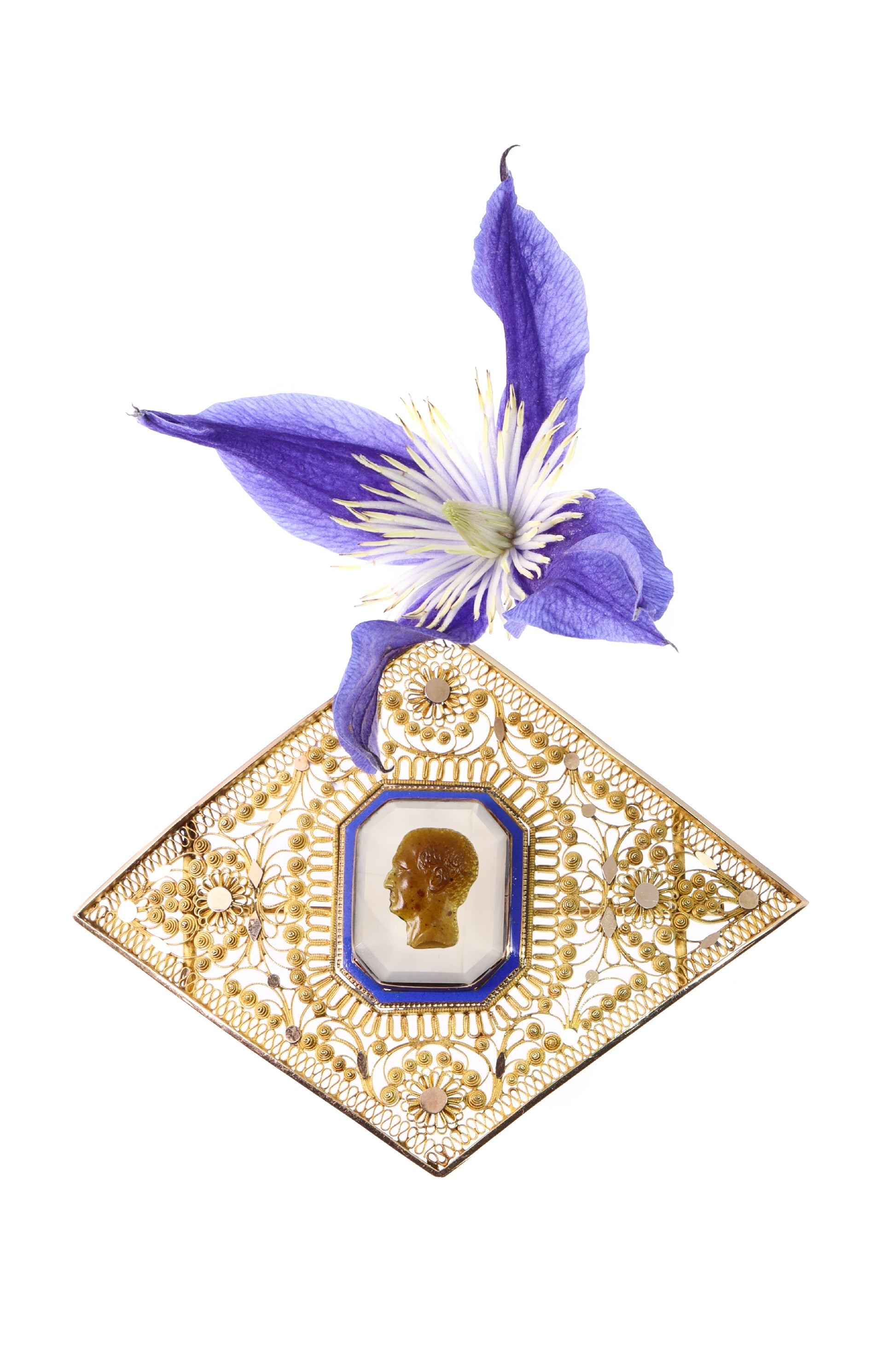A yellow gold ornate openwork brooch with an agate cameo portrait in the centre, bordered with blue enamel, with a purple flower