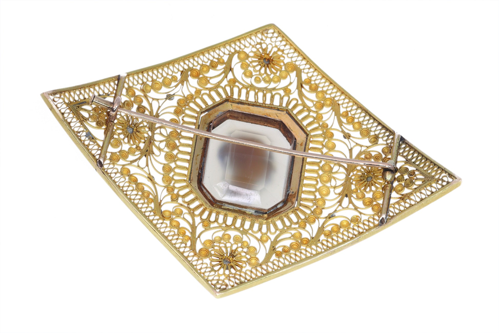 A yellow gold ornate openwork brooch with an agate cameo portrait in the centre, bordered with blue enamel