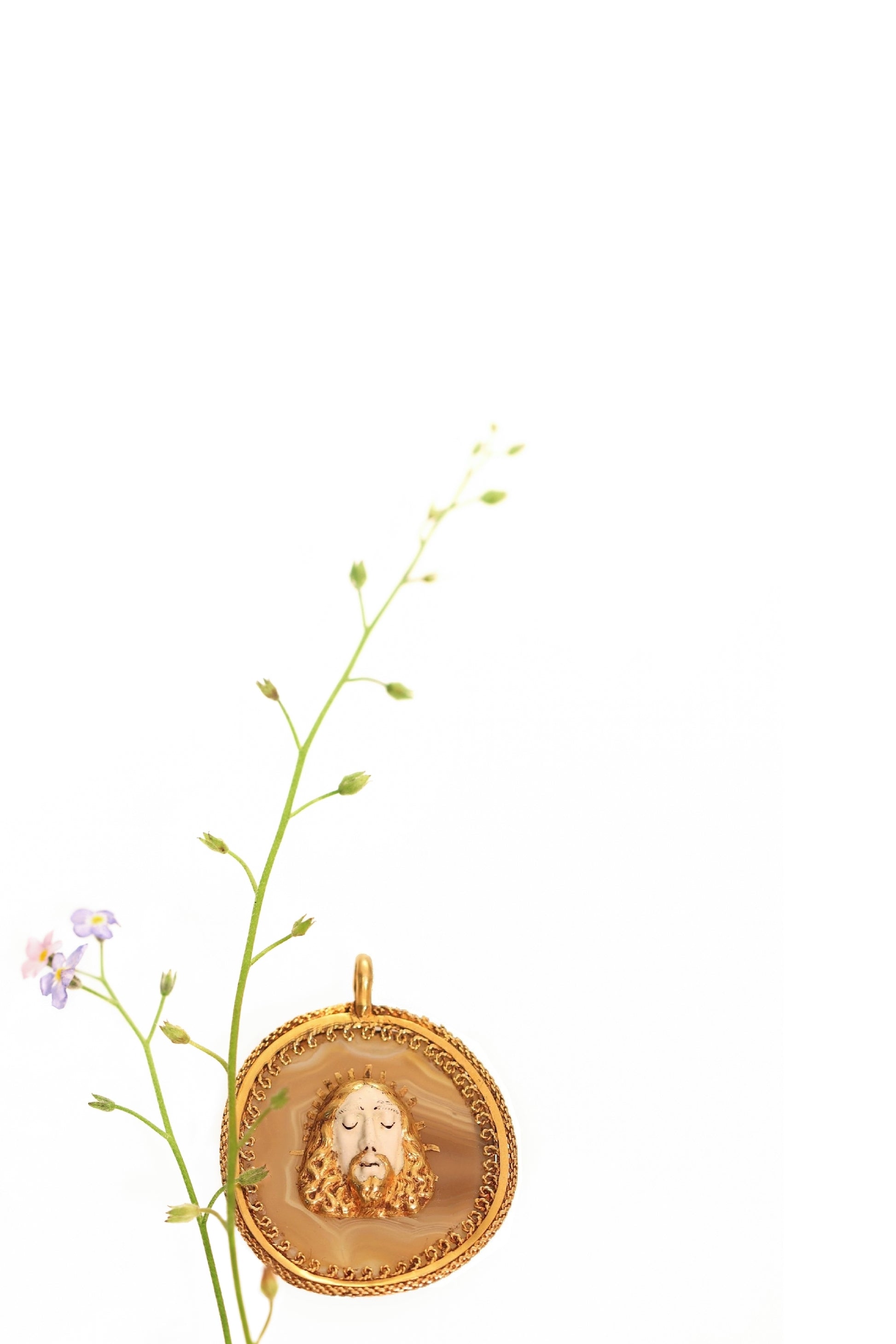 An enamelled face of Christ on a banded agate and yellow gold wirework pendant, with flowers