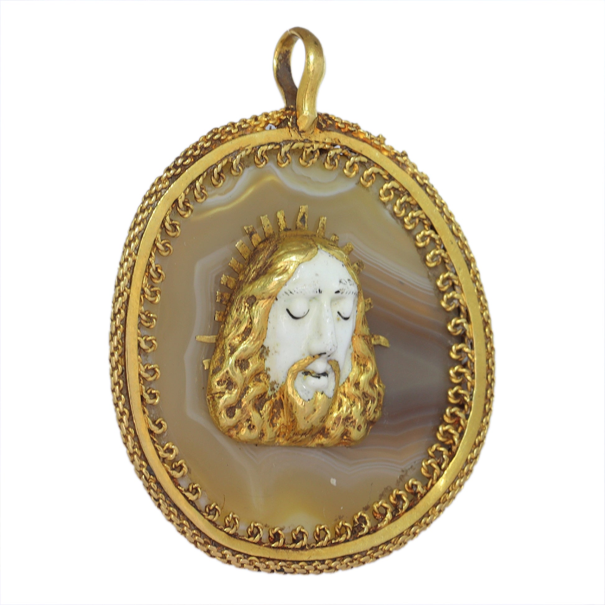An enamelled face of Christ on a banded agate and yellow gold wirework pendant