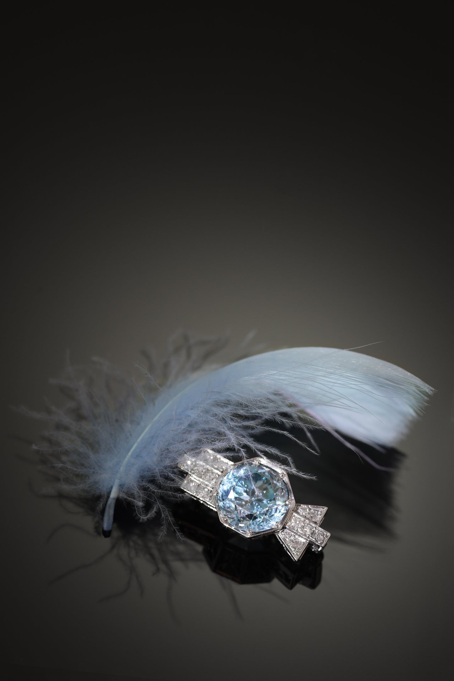 A blue zircon and diamond geometric designed brooch in platinum, with a blue feather