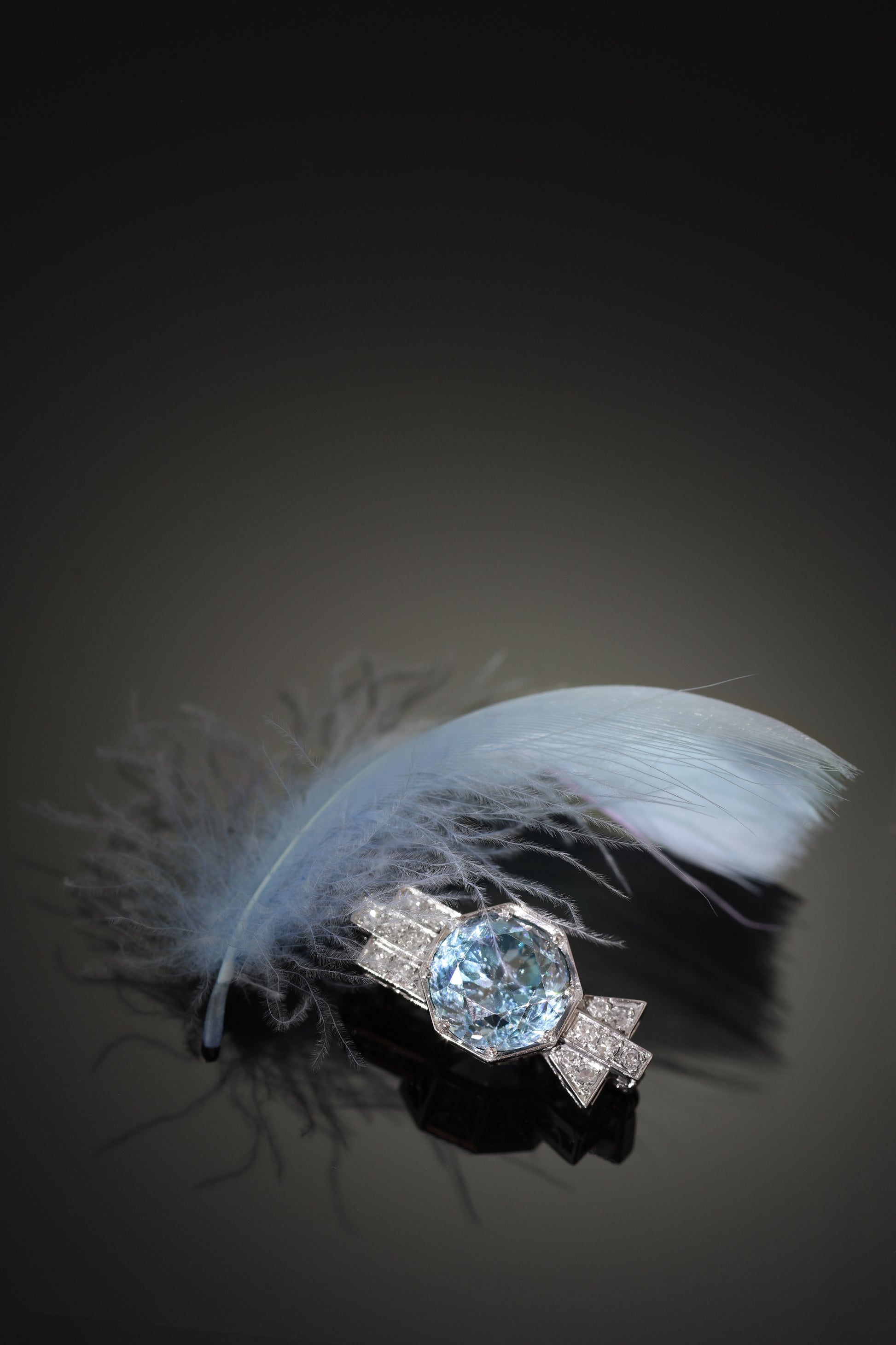 A blue zircon and diamond geometric designed brooch in platinum, with a blue feather