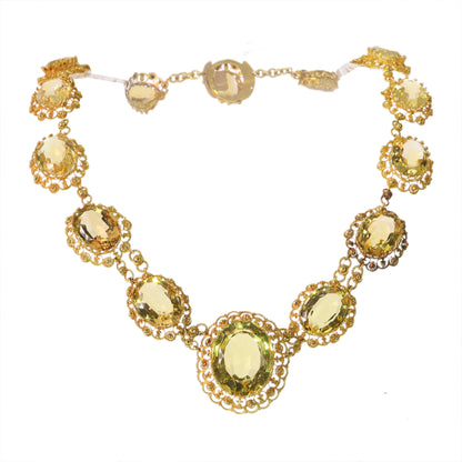 An intricate yellow gold necklace set with oval citrines in filigree mounts