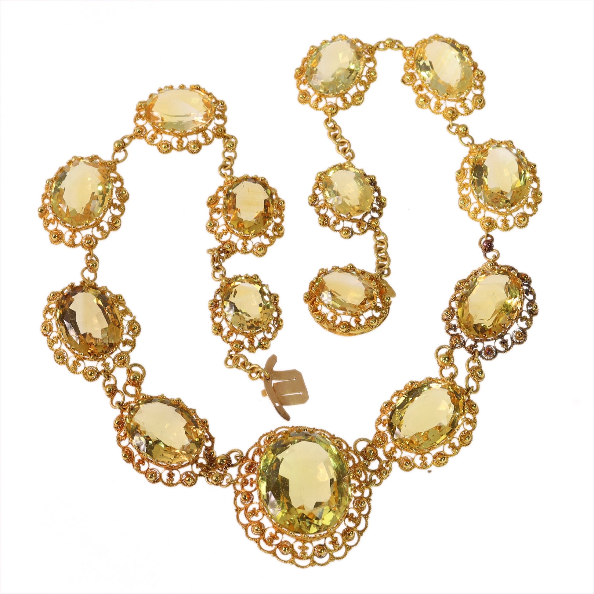 An intricate yellow gold necklace set with oval citrines in filigree mounts