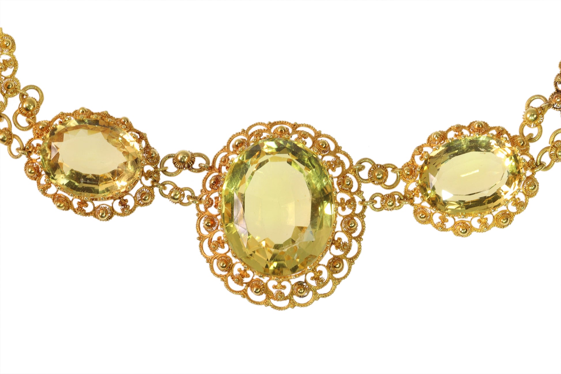 An intricate yellow gold necklace set with oval citrines in filigree mounts