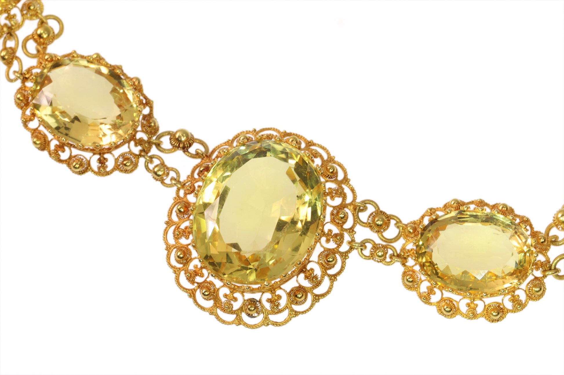 An intricate yellow gold necklace set with oval citrines in filigree mounts