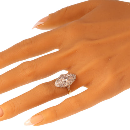 A navette shaped cluster ring set with diamonds in yellow and white gold, modelled on a hand