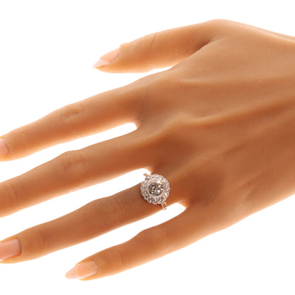 A brilliant cut diamond scalloped edge cluster ring in platinum, modelled on a hand