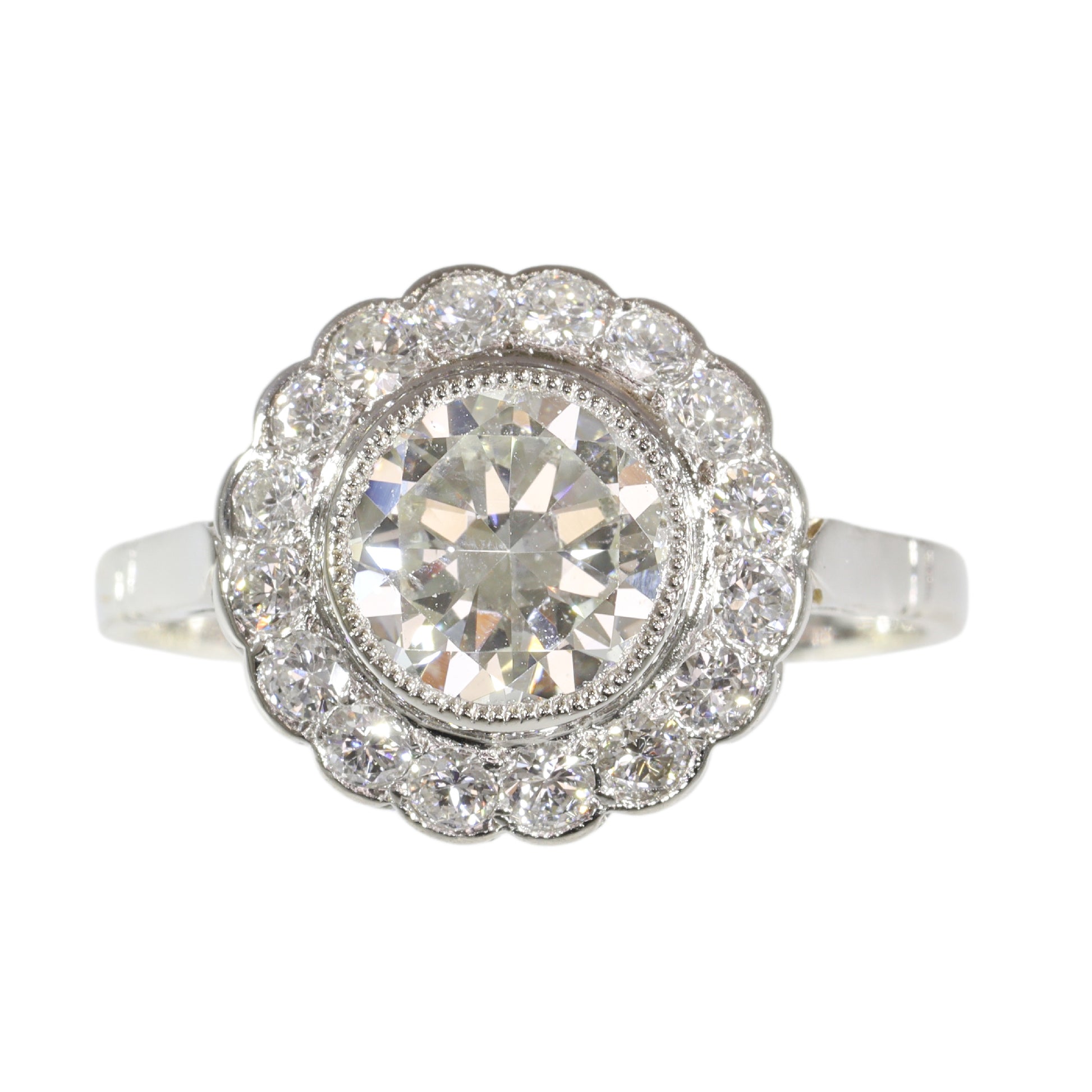 A brilliant cut diamond scalloped edge cluster ring in platinum