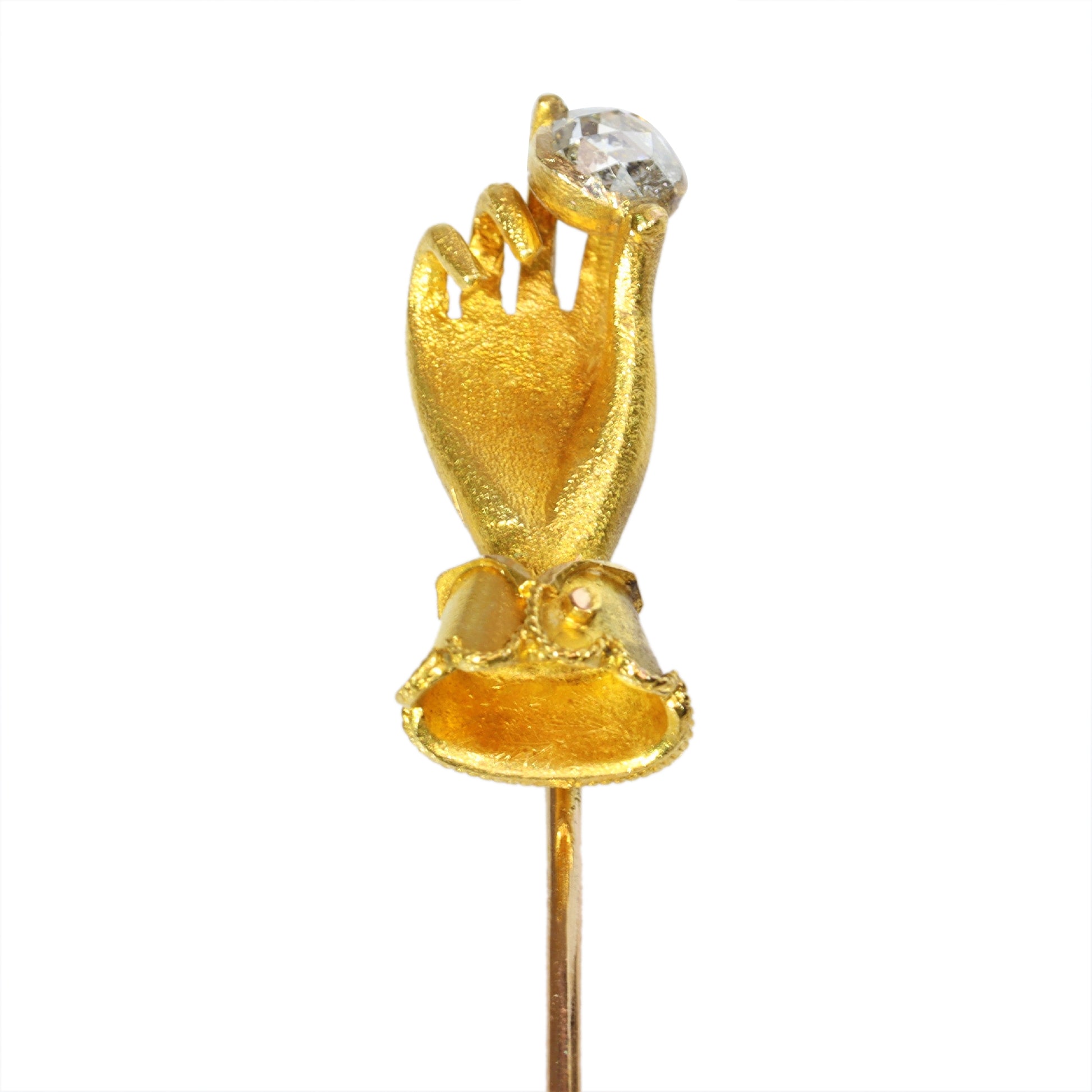 A yellow gold hand holding a diamond stick or tie pin