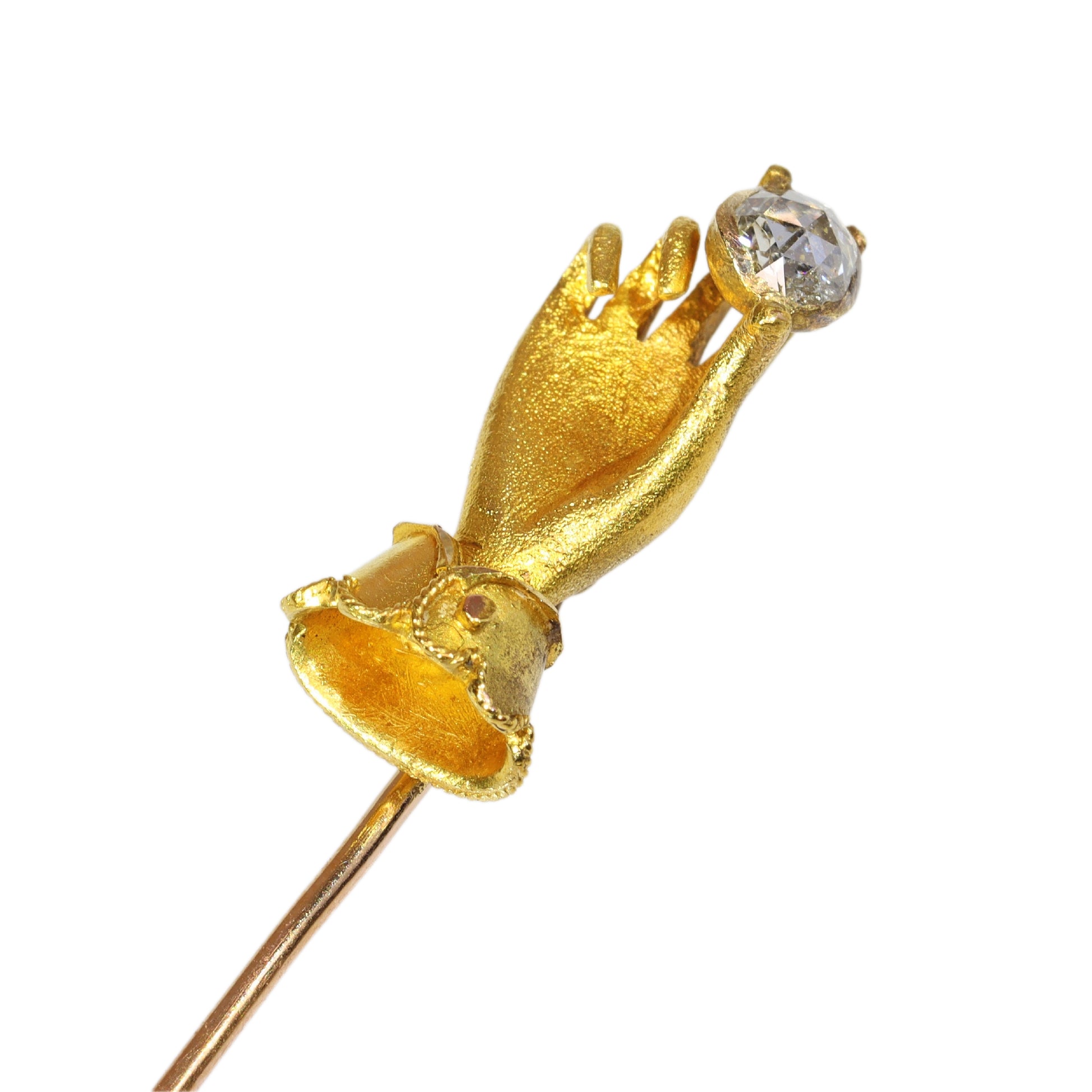 A yellow gold hand holding a diamond stick or tie pin