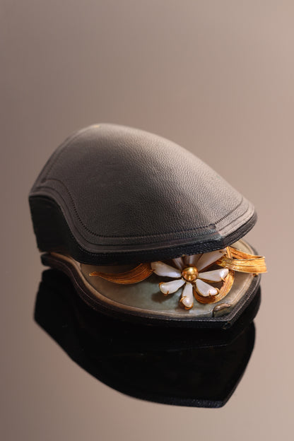 An antique yellow gold flower brooch with elongated white pearls, in an antique box
